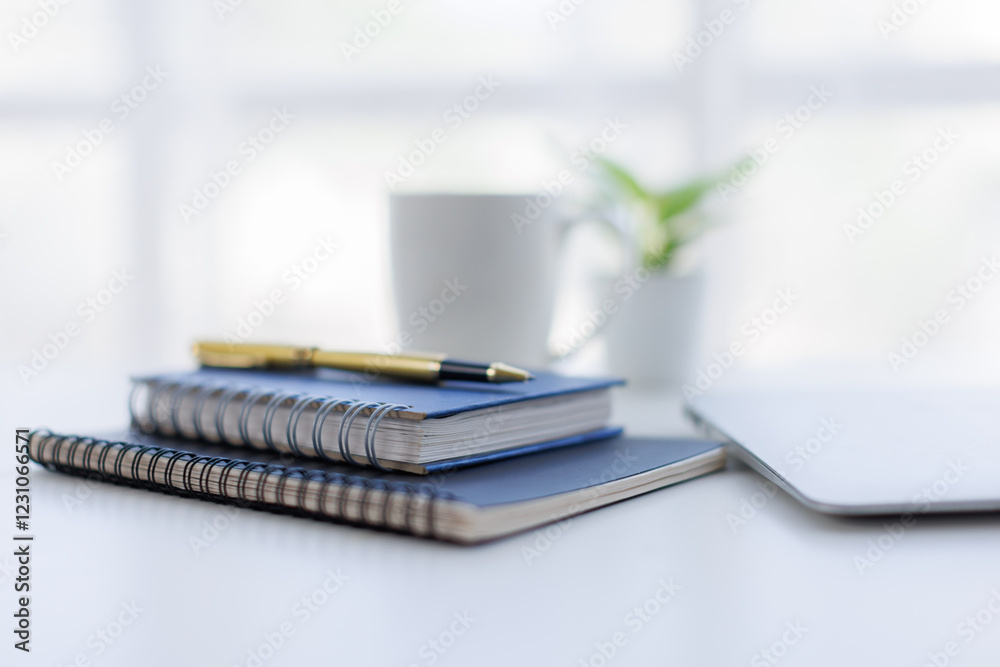 Laptop Computer, notebook, office space ,and eyeglasses sitting on a desk in a large open plan office space after working hours Laptop Computer, notebook, office space ,and eyeglasses sitting on a desk in a large open plan office space after working hours