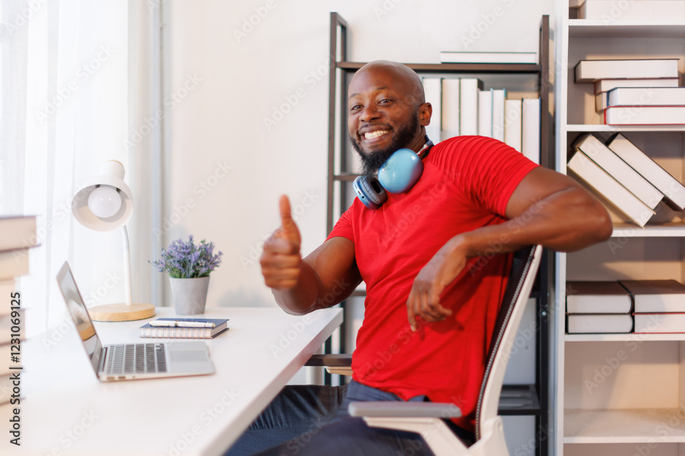 Happy and smiling African American Typing e-mail to his customer. He has online virtual meeting on laptop computer at home. Happy and smiling African American Typing e-mail to his customer. He has online virtual meeting on laptop computer at home.