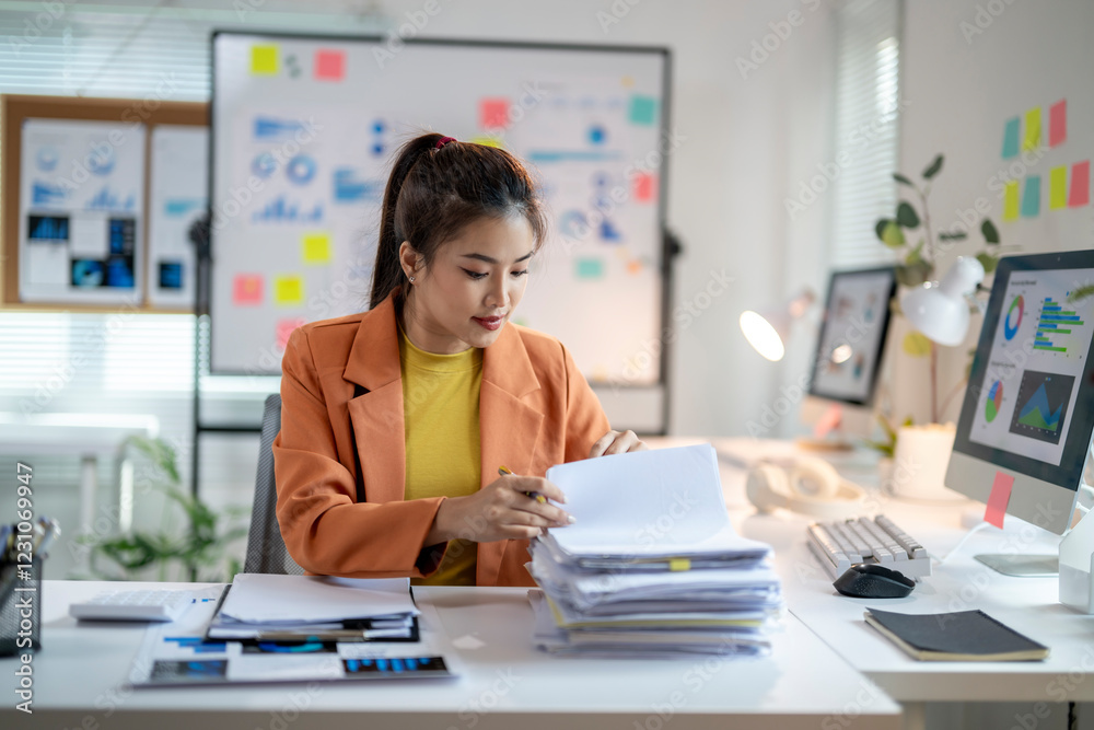 She is looking at the papers and she is focused on her work She is looking at the papers and she is focused on her work