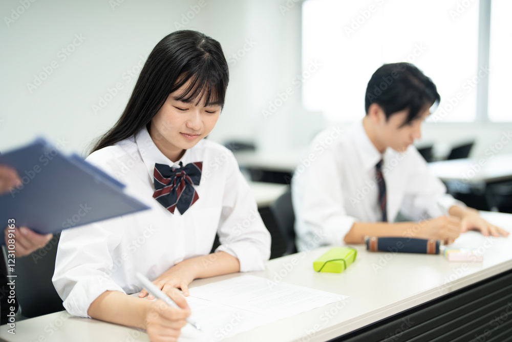 高校の制服を着たアジアのティーンエイジャーが授業でテストを行う