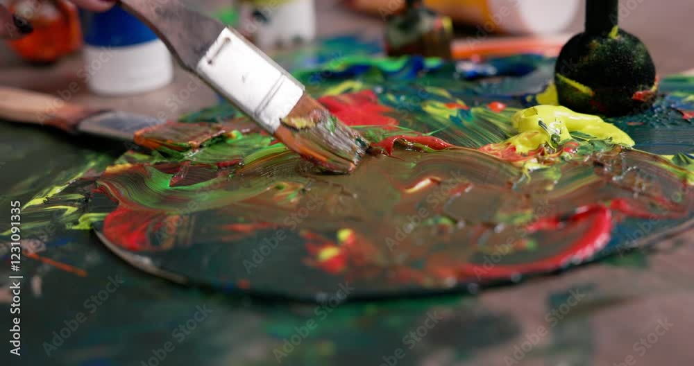 Artistic paint mixing happens with a brush on a palette, showcasing creativity and color Artistic paint mixing happens with a brush on a palette, showcasing creativity and color