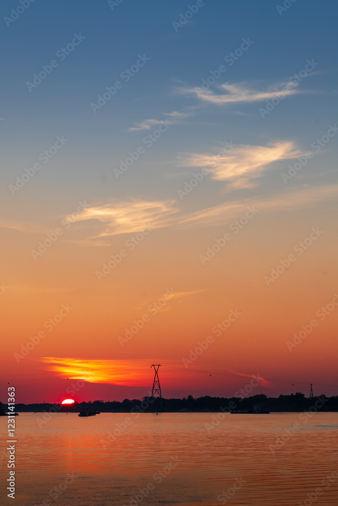 Red summer sunset over the river Volga. Silhouettes of ships on the river and a cable car Red summer sunset over the river Volga. Silhouettes of ships on the river and a cable car