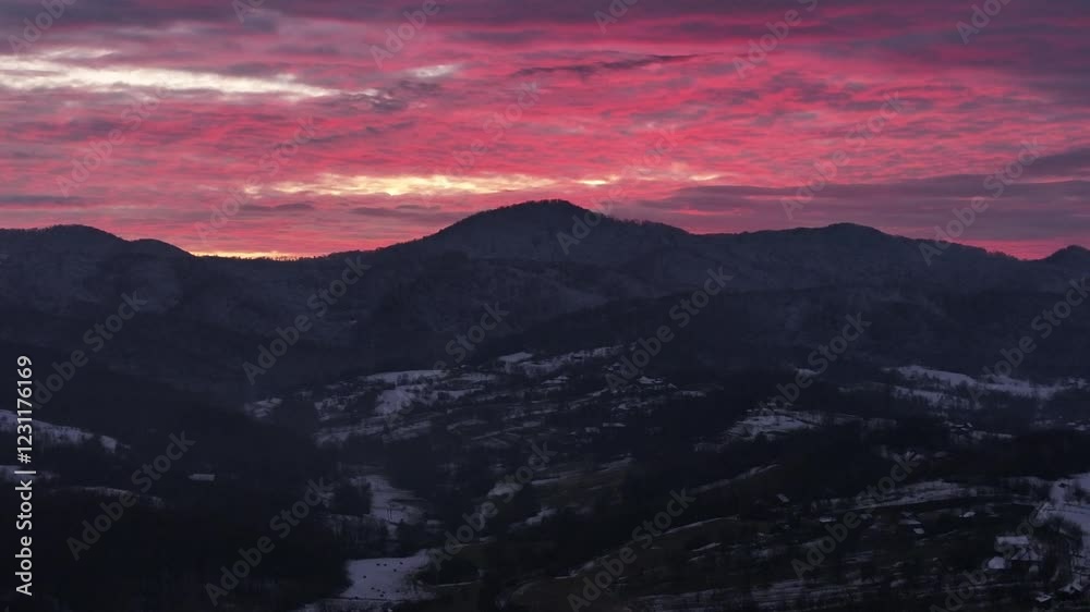 Captivating aerial view of a sunset over snow-covered mountains, showcasing vibrant skies and peaceful winter landscapes Captivating aerial view of a sunset over snow-covered mountains, showcasing vibrant skies and peaceful winter landscapes
