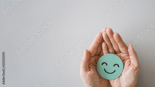 Hands holding smile emoji face, positive mental health, world mental health day concept.