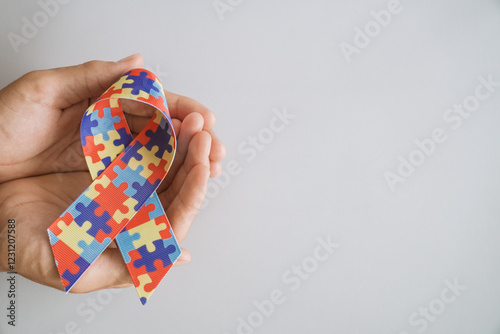 hands holding jigsaw puzzle ribbon, Autism awareness,Autism spectrum disorder family support concept, World Autism Awareness Day. photo