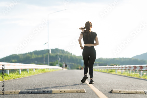 A woman in sportswear running in the park, enjoying fresh air, engaging in outdoor activities to maintain a healthy lifestyle, boosting cardiovascular health, and feeling happy and energetic photo