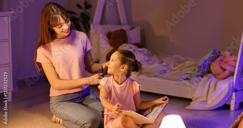 Mother brushing her little ...