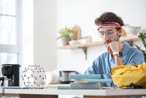 Male student studying at ta...