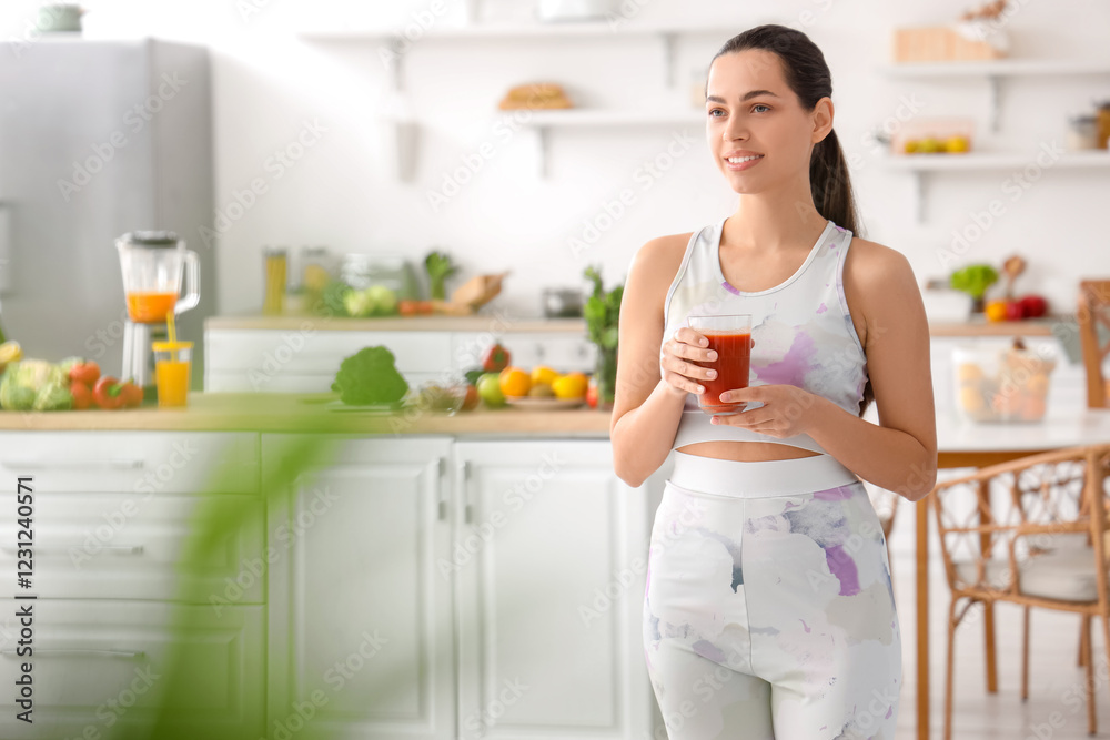 Sporty young woman with glass of vegetable juice in kitchen Sporty young woman with glass of vegetable juice in kitchen
