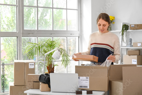 Young woman packing parcel ...
