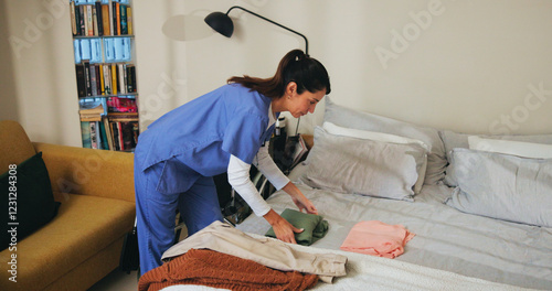Woman, nurse and fold clothes in home, household tasks and caregiver helping in assisted living. Female person, volunteer and support with outfit plan in bedroom, nursing village and professional