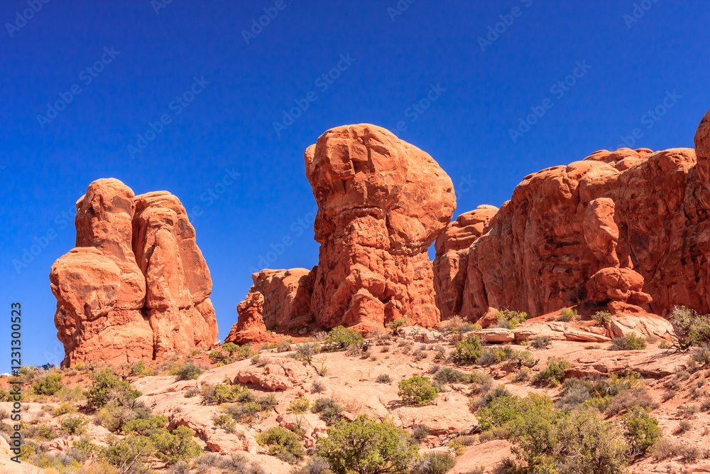Fototapeta premium A rocky landscape with three large rocks, each with a distinct shape