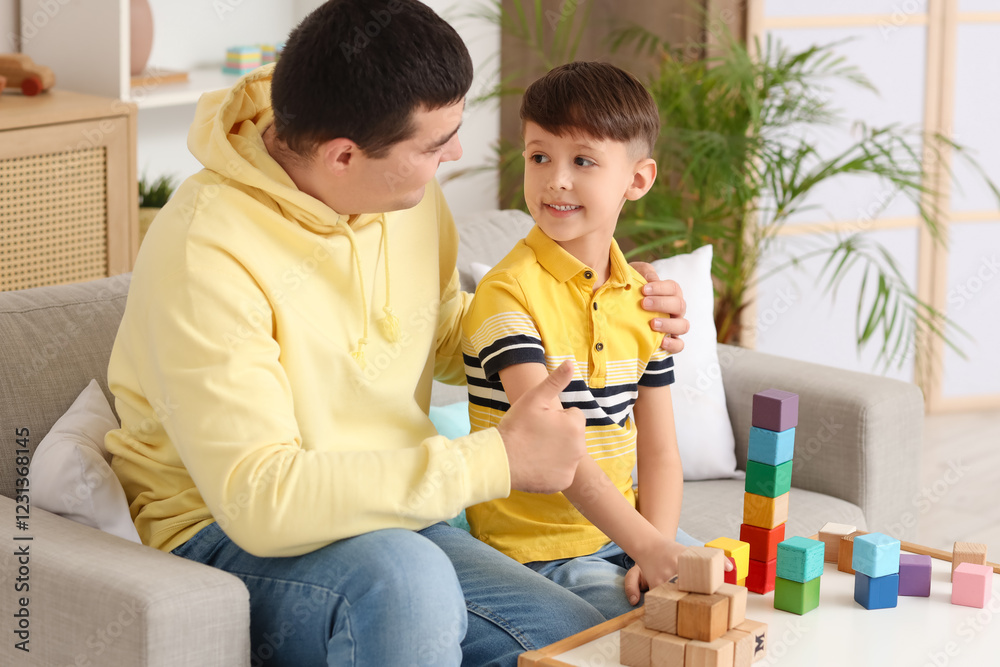 Father hugging his little son with colorful cubes on table at home Father hugging his little son with colorful cubes on table at home