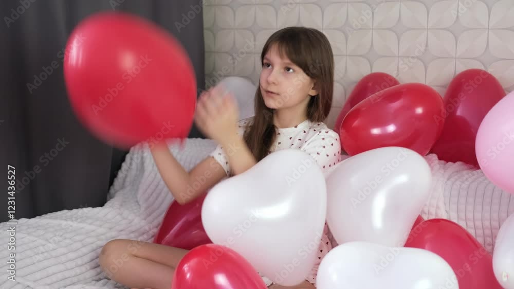 ittle girl surrounded by red balloons. in the shape of heart is having fun and fooling around. Valentine's Day concept. Blurred motion. ittle girl surrounded by red balloons. in the shape of heart is having fun and fooling around. Valentine's Day concept. Blurred motion.