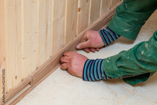 A man is working on a wooden wall with his hands