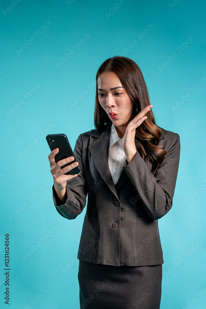 Asian businesswoman using phone video call in isolated blue background. Asian businesswoman using phone video call in isolated blue background.