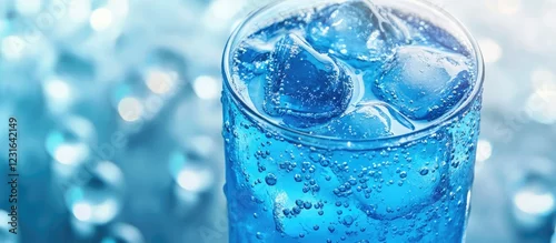 Obraz  z motywem Vibrant blue soda drink in a clear glass filled with ice cubes, bubbles rising against a soft focus turquoise background, inviting a refreshing experience