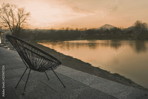 Wicker armchair by the river in the early evening photo