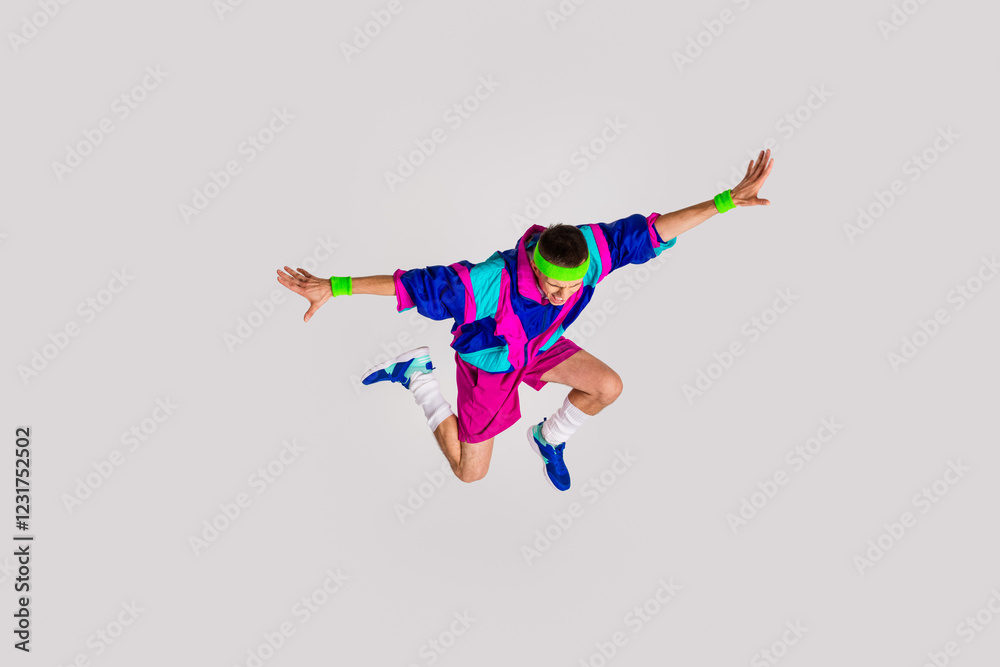 Obraz premium Energetic young man in retro sportswear jumping against light gray background