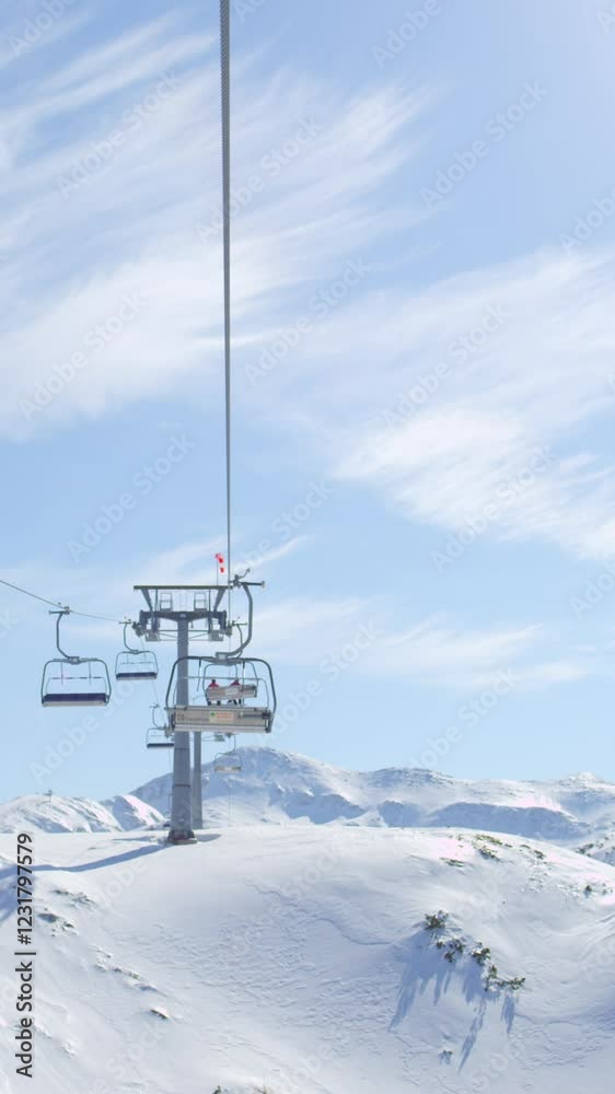 Riding the ski lift in sunny ski resort in snowy winter Riding the ski lift in sunny ski resort in snowy winter