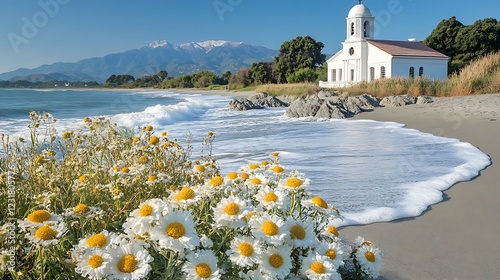 A coastal church overlooking the ocean with waves crashing on nearby rocks photo