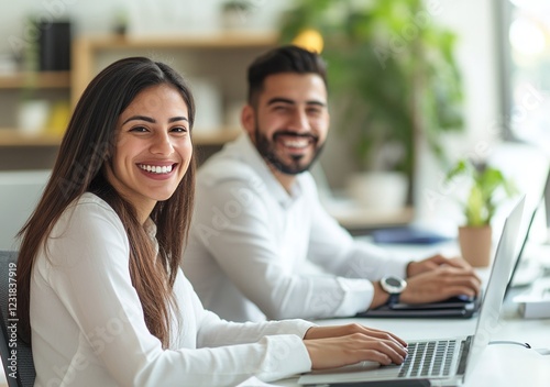 Hombres y mujeres hispanos trabajando en una oficina. Ellos se están riendo.