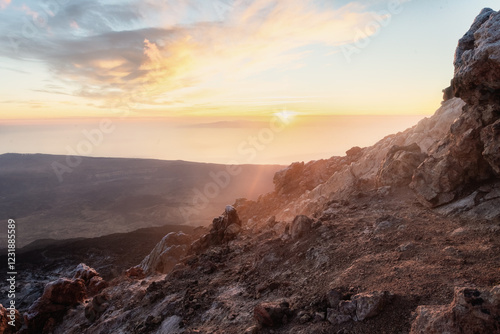 Lever de soleil spectaculaire depuis le sommet du volcan Teide à Tenerife. Vue panoramique sur un paysage volcanique unique, baigné de lumière dorée, offrant une atmosphère mystique au-dessus des nuag