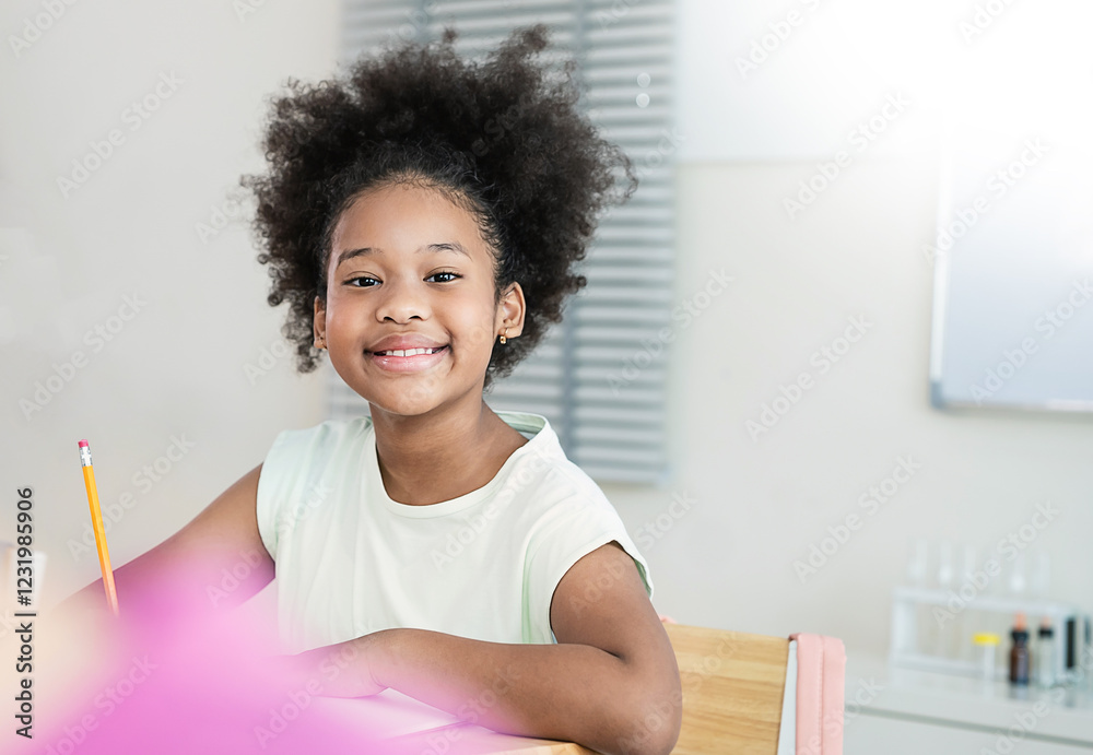Fototapeta premium Portrait of little pupil writing at desk in classroom at the elementary school. Student African girl doing test in primary school. Children writing notes in classroom. Education knowledge