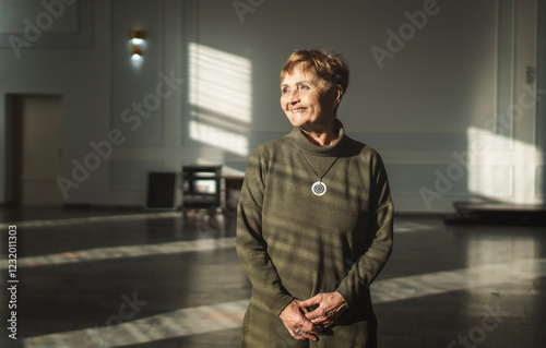 Obraz na płótnie Portrait of Caucasian beautiful elderly senior woman with short haircut and dreamy face, with beautiful light falling from window w salonie