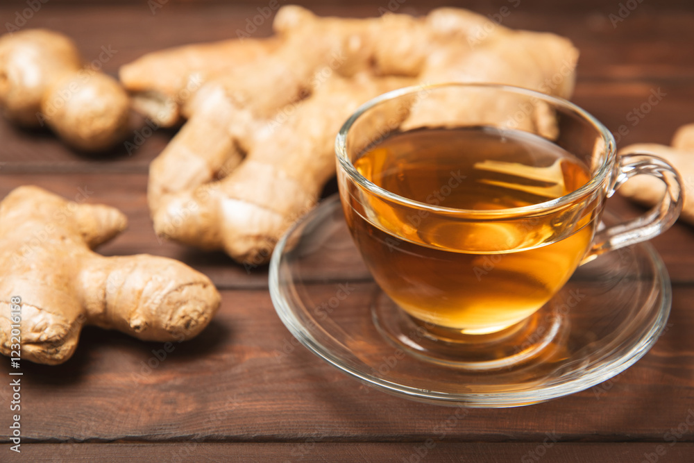 Cup of hot ginger tea with slices of ginger root on wooden background. Warming drink. Alternative medicine. Tea with honey, lemon, ginger and mint. Space for text. Copy space Cup of hot ginger tea with slices of ginger root on wooden background. Warming drink. Alternative medicine. Tea with honey, lemon, ginger and mint. Space for text. Copy space