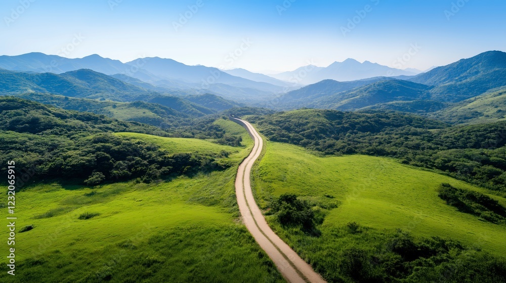 Fototapeta premium Scenic landscape with winding road and rolling hills under clear blue sky in the mountains during daytime