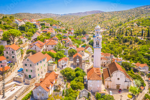 Ložišća, a charming village on Brač Island, Croatia, known for its traditional stone houses, narrow streets, and the historic Church of St. John and Paul with its iconic bell tower. photo