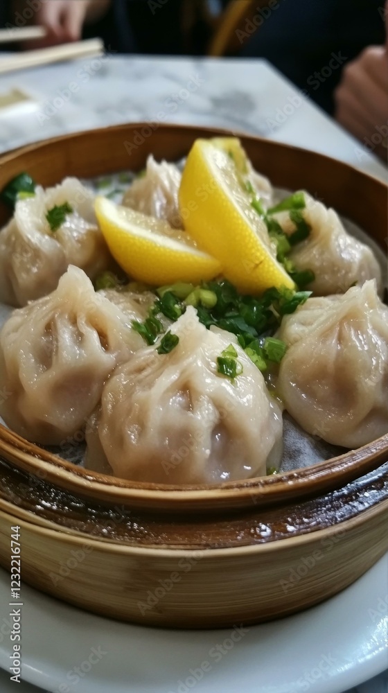 Steamed Dumplings with Lemon Garnish in Bamboo Steamer Basket on Tabletop Food Arrangement Steamed Dumplings with Lemon Garnish in Bamboo Steamer Basket on Tabletop Food Arrangement