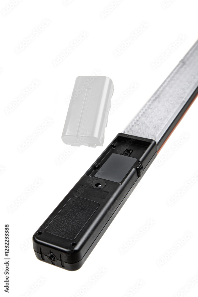 A close-up of a black handheld device with an open battery compartment and a detached battery.