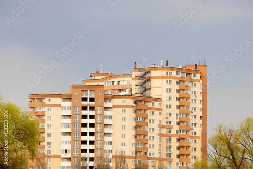 Tall modern apartment building. Architectural design of residential skyscraper. Building with windows, balconies and infrastructure