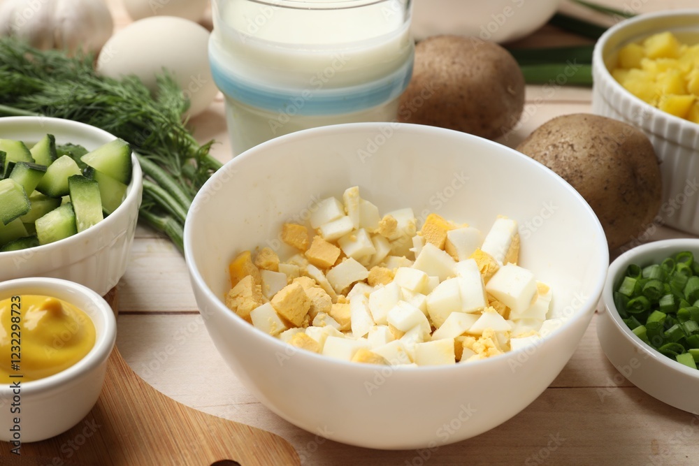Fresh ingredients for okroshka soup on light wooden table, closeup