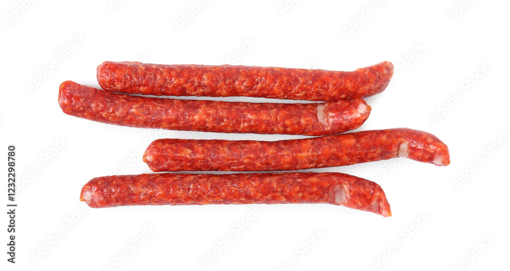 Many thin dry cured sausages isolated on white, top view