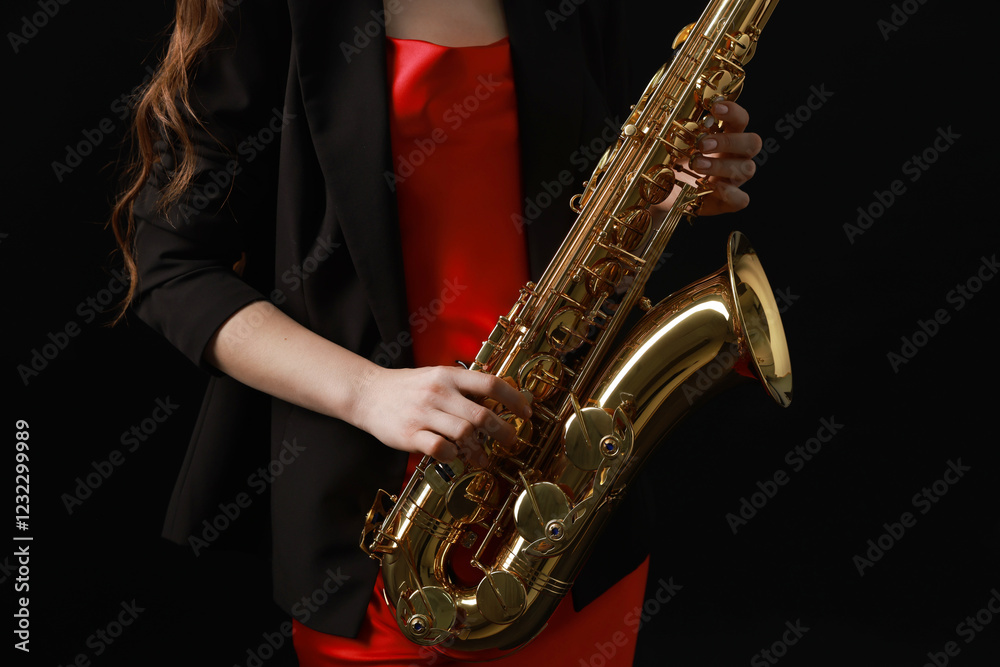 Obraz premium Professional musician with saxophone on black background, closeup