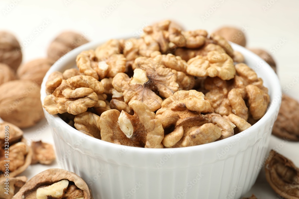 Peeled walnuts in bowl on light table, closeup Peeled walnuts in bowl on light table, closeup