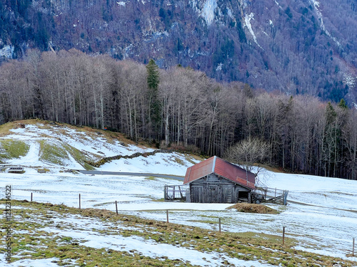 Old traditional swiss rural architecture and alpine livestock farms in the winter ambience over the tourist resort of Engelberg in Swiss Alps - Canton of Obwalden, Switzerland (Kanton Obwald, Schweiz)
