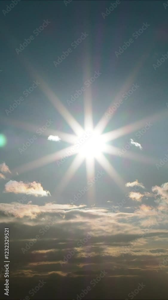 Vertical video - sun rays illuminate the sky and clouds, casting sun bunnies, giving the lens backlighting