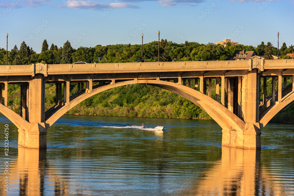 A bridge spans a river with a boat in the water A bridge spans a river with a boat in the water