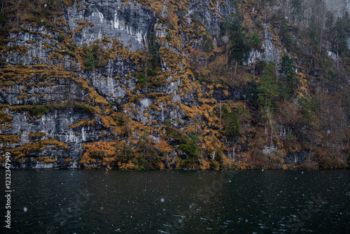 Fototapeta Naklejka Na Ścianę i Meble -  Misty lake surrounded by rocky cliffs and autumn foliage in the rain