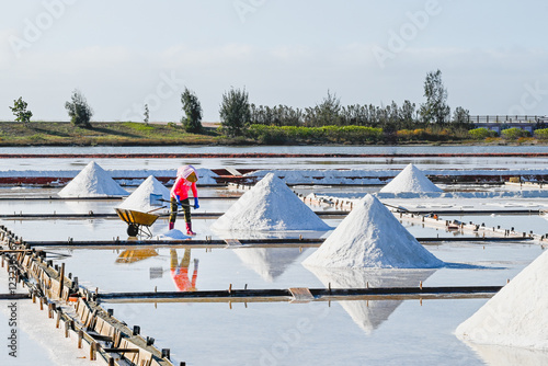 Tainan City, Taiwan - NOV 19, 2022: Jingzaijiao Tile-Paved Salt Fields.salt field worker. photo