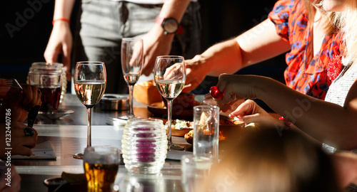 Gathering around a dinner table enjoying delicious food and drinks during a lively evening at a cozy restaurant in the city
