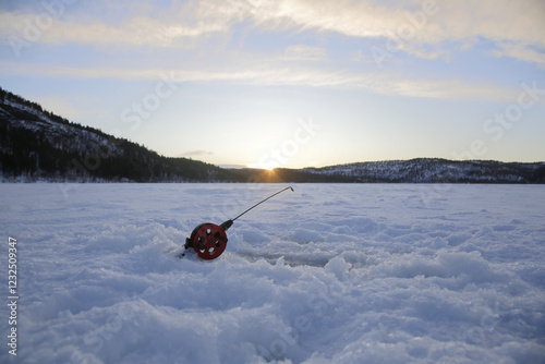 Pesca nel lago ghiacciato di Storvannet (Kulojarvi) di mattina vicino Alta. Il sole torna a gennaio. Norvegia del Nord. photo