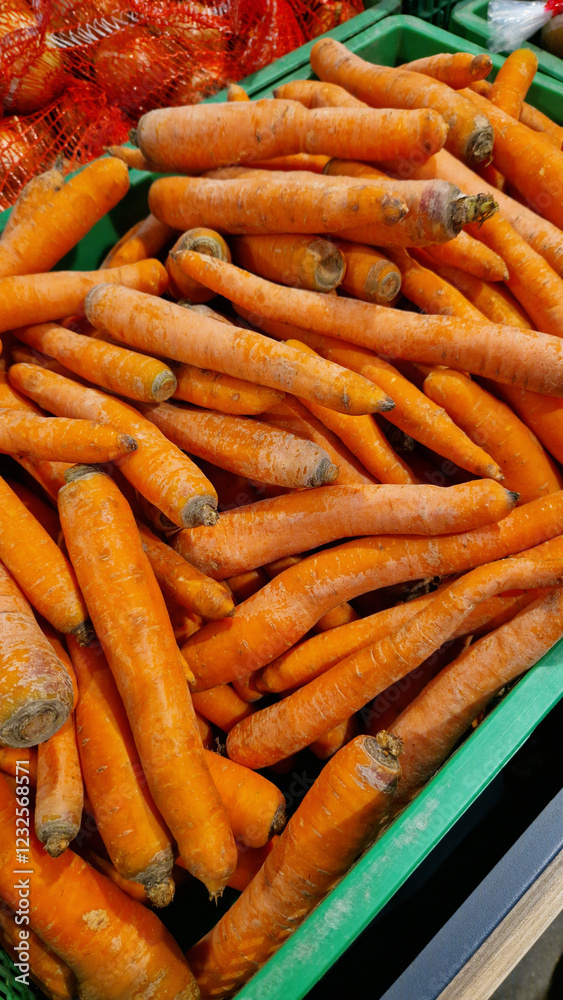 Washed ripe carrots on sale in the store. Carrots close-up. Vegetable crop. A pile of washed carrots in a plastic box, selective focus. Vegetables in the supermarket close-up Washed ripe carrots on sale in the store. Carrots close-up. Vegetable crop. A pile of washed carrots in a plastic box, selective focus. Vegetables in the supermarket close-up