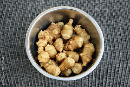 Jerusalem artichoke (Helianthus tuberosus) tubers, just harvested. Washed tubers in a bowl  photo