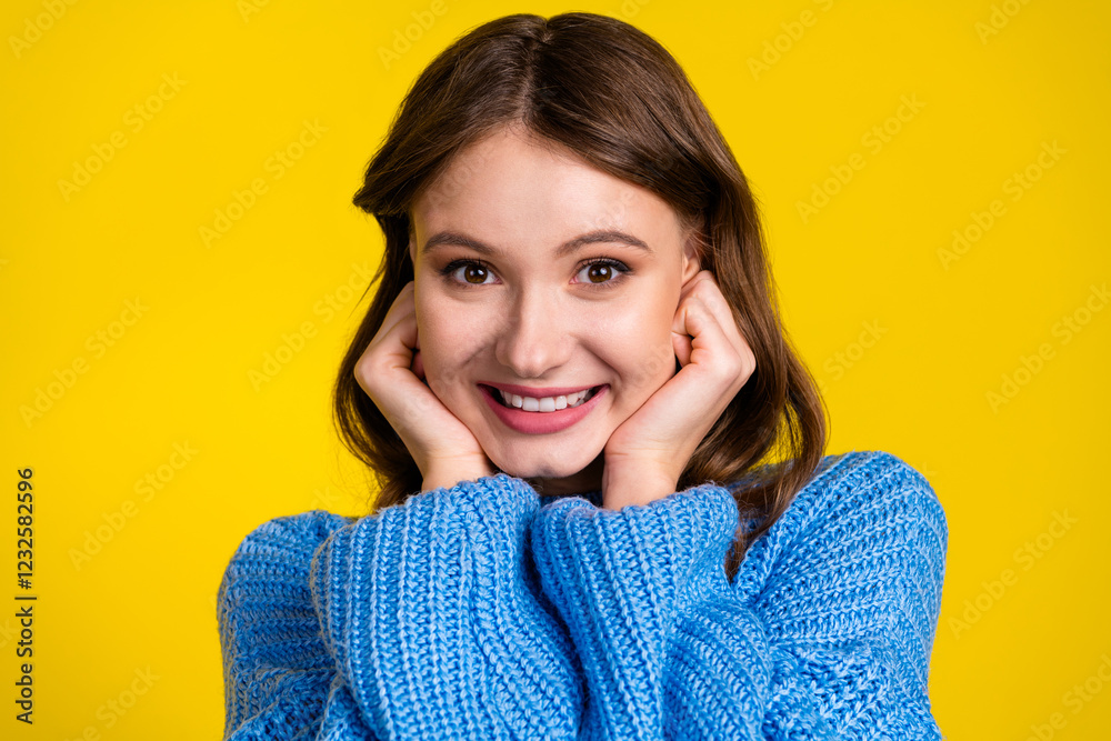 Portrait of a young woman in a blue sweater against a vibrant yellow background Portrait of a young woman in a blue sweater against a vibrant yellow background