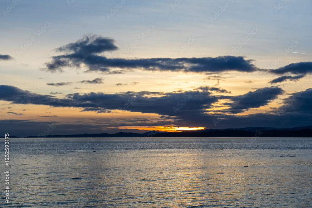 Obraz premium Scenic Sunset Over Vancouver Island Coastline With Serene Ocean Waters and Dramatic Clouds